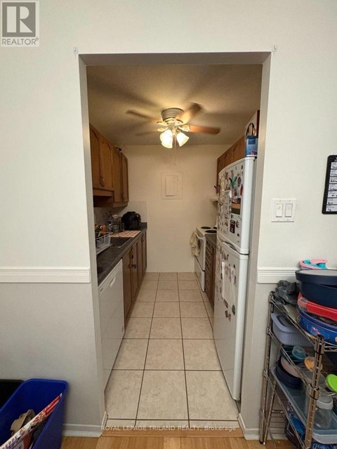 A kitchen with a white fridge and a white ceiling fan.