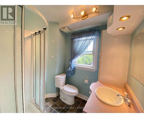 A bathroom with a toilet, sink, and shower.