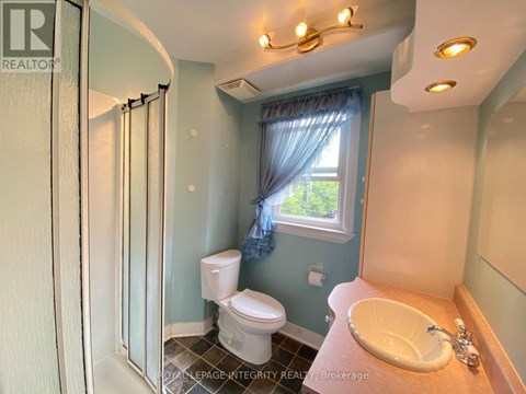 A bathroom with a toilet, sink, and shower.