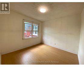 A room with a window and wooden flooring.