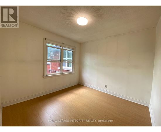 A room with a window and wooden flooring.