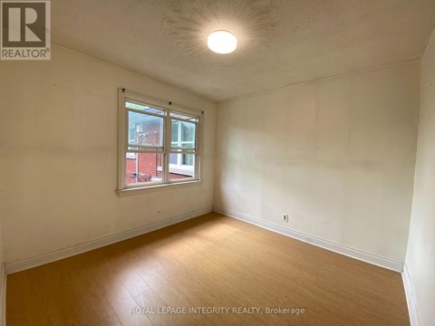 A room with a window and wooden flooring.
