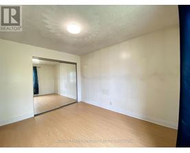 A room with a sliding glass door and wooden flooring.