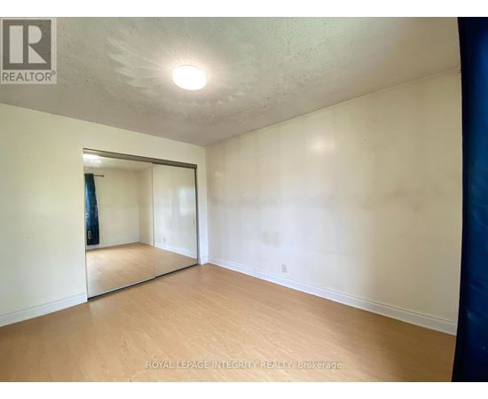 A room with a sliding glass door and wooden flooring.