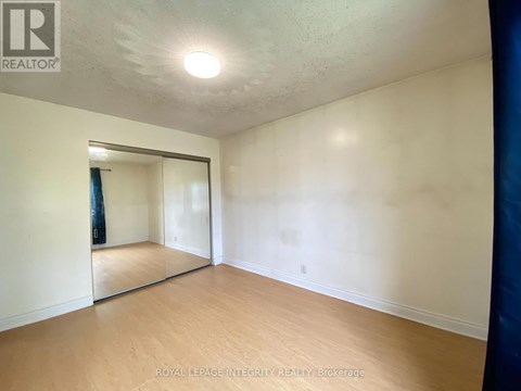 A room with a sliding glass door and wooden flooring.