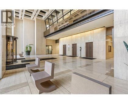 A lobby with a row of chairs and a plant.