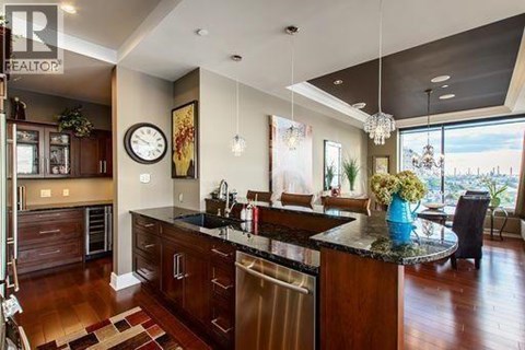 A modern kitchen with dark wood cabinets and a large island.