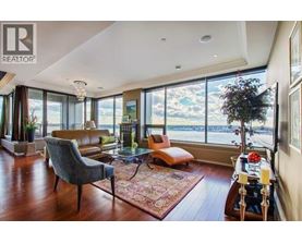 A living room with a large window overlooking the water.
