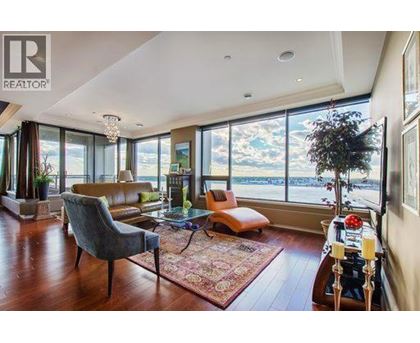 A living room with a large window overlooking the water.
