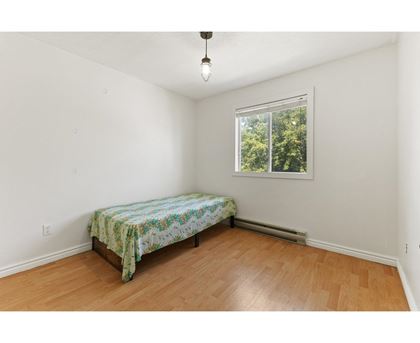 A bedroom with a bed and a window.
