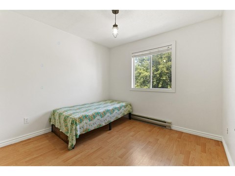 A bedroom with a bed and a window.