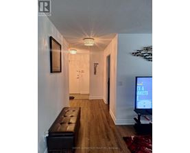 A hallway with a bench and a television on the right side.