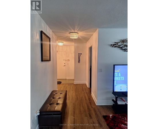 A hallway with a bench and a television on the right side.