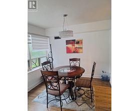 A dining room with a table and chairs.