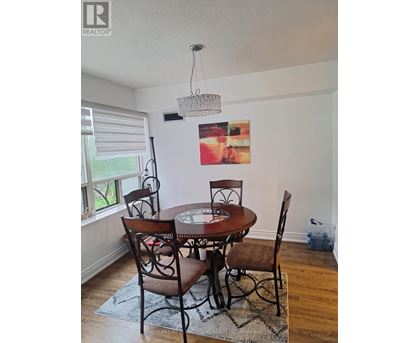 A dining room with a table and chairs.
