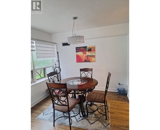 A dining room with a table and chairs.