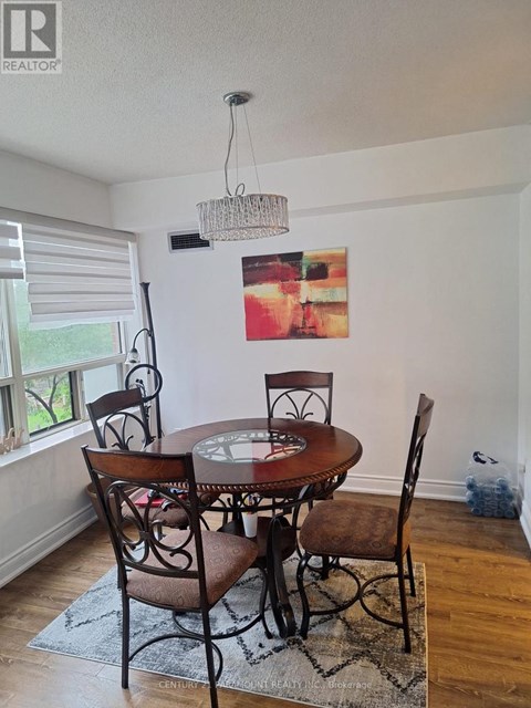 A dining room with a table and chairs.