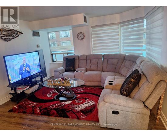 A living room with a couch, a coffee table, and a television.
