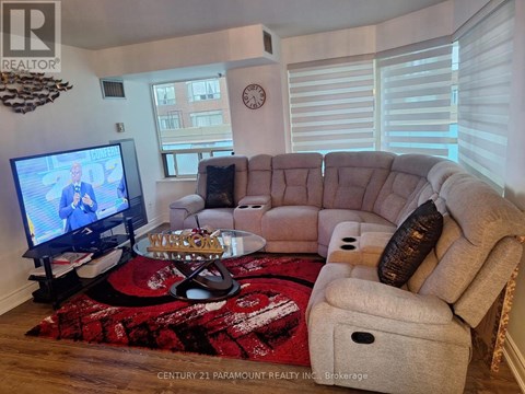A living room with a couch, a coffee table, and a television.