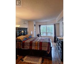A bedroom with a bed, dresser, and window.
