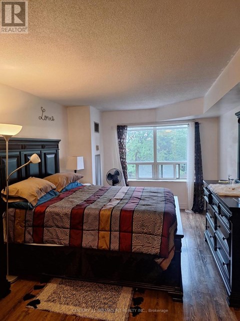 A bedroom with a bed, dresser, and window.