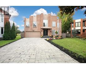 A brick house with a driveway in front.