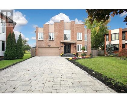 A brick house with a driveway in front.