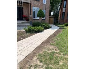 A brick house with a stone walkway in front.