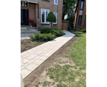 A brick house with a stone walkway in front.