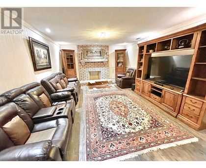 A living room with leather chairs and a rug.