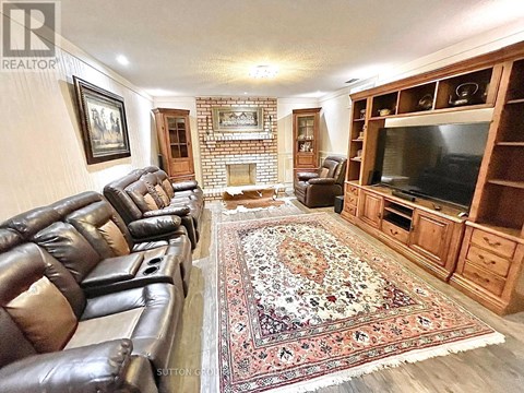 A living room with leather chairs and a rug.