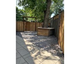 A backyard with a hot tub and a fence.