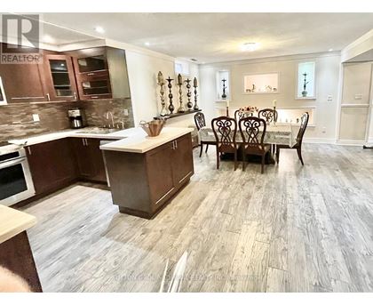 A kitchen with a dining table and chairs.