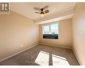 A room with a ceiling fan and a window letting in sunlight.