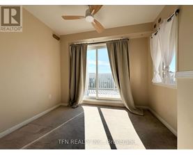 A room with a ceiling fan and a view of a balcony.