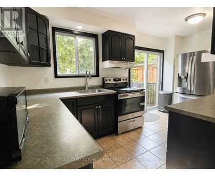 A kitchen with black cabinets and stainless steel appliances.