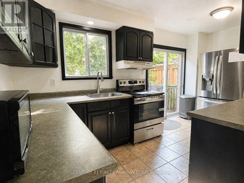 A kitchen with black cabinets and stainless steel appliances.
