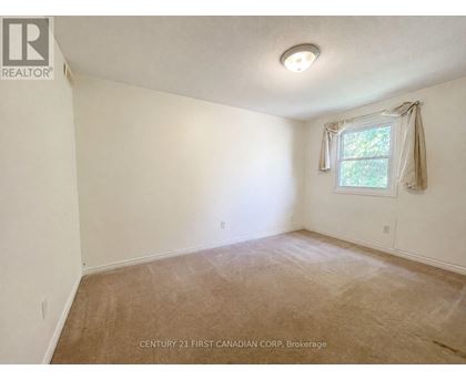 A room with a window and a carpeted floor.