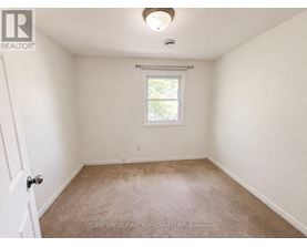 A room with a window and carpeted floor.