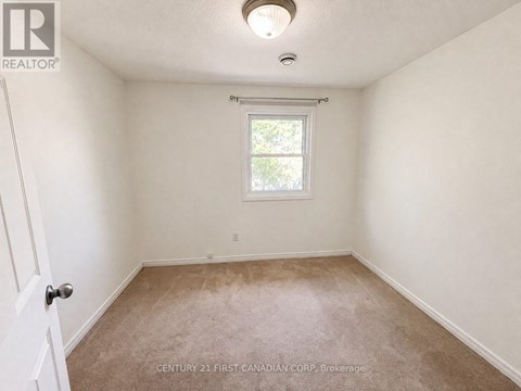 A room with a window and carpeted floor.