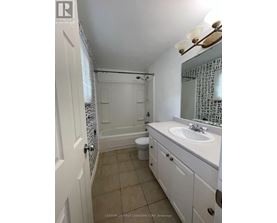A white bathroom with a toilet, sink and shower.