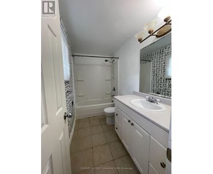 A white bathroom with a toilet, sink and shower.
