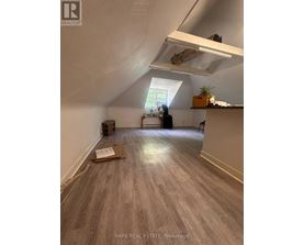 A room with a box on the floor and a window letting in light.