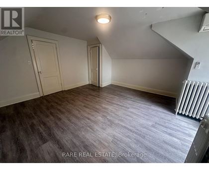 A room with a box on the floor and a window letting in light.