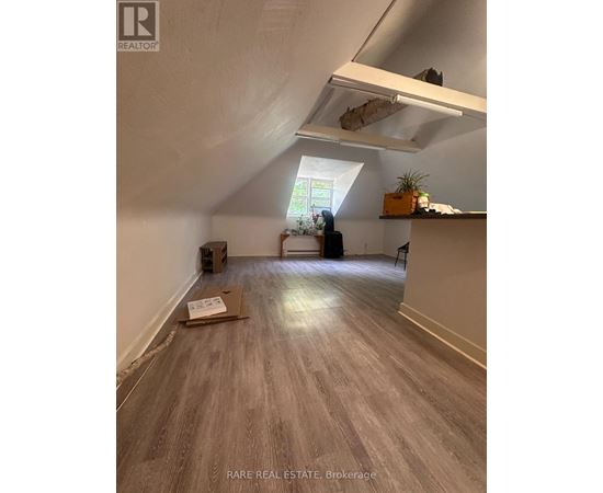 A room with a box on the floor and a window letting in light.