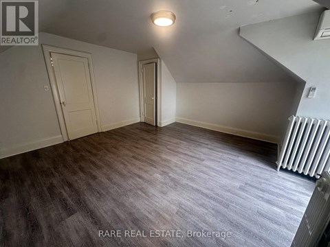A room with a box on the floor and a window letting in light.
