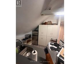 A kitchen with a sink, stove, and cabinets.