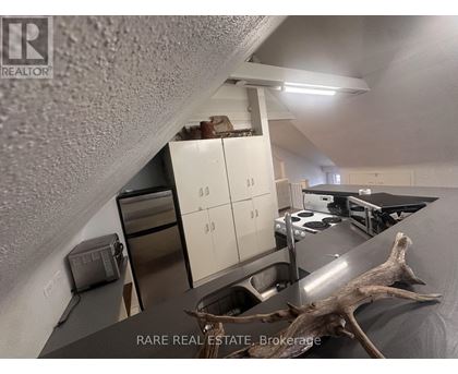 A kitchen with a sink, stove, and cabinets.