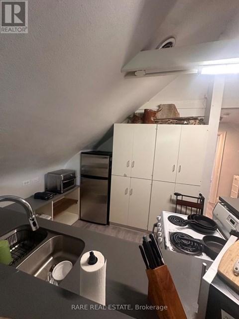 A kitchen with a sink, stove, and cabinets.
