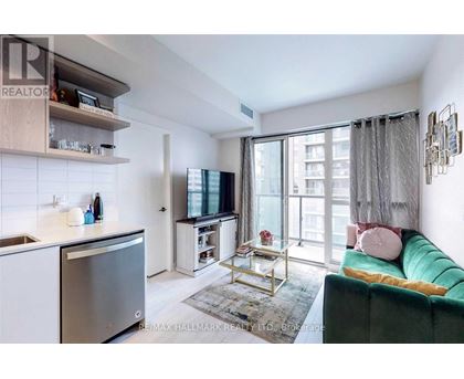 A modern kitchen with a green couch and a TV.
